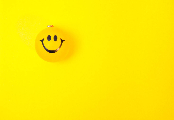 Photo of a yellow smiley face on yellow background - Fotografie, Obrázek