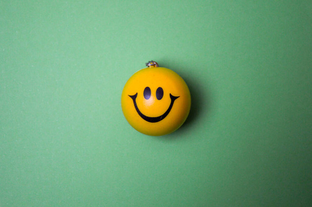 Photo of a yellow smiley face on green background - Foto, Imagen