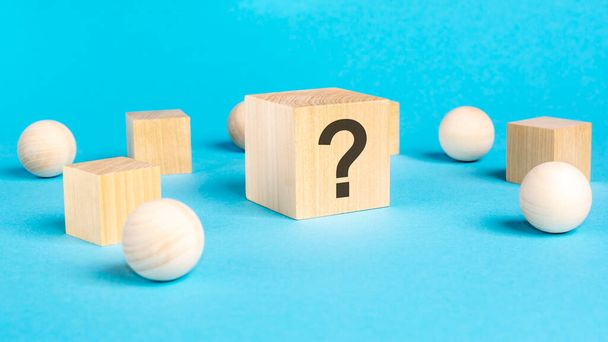 natural wooden cubes with question marks, bright blue background, business concept - Photo, Image