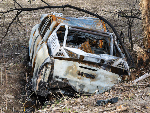 Road traffic accident of a car with fire. Car accident. Road in the forest. Damaged transport. Asphalt pavement. Traffic Laws. Military actions. Motor vehicle. Ukraine. - Foto, Bild