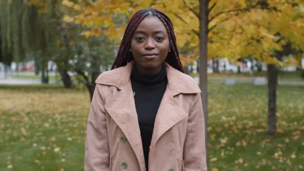 Young positive woman stands in autumn park nods head positively approvingly answers social survey questions joyful stylish girl agrees to profitable offer nodding in agreement approves gives consent - Video