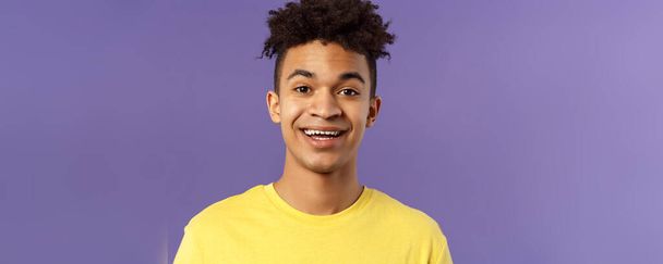 Close-up portrait of cheerful smiling man looking happy, express enthusiastic optimistic emotions, seeing something pleasant and interesting, standing purple background. - Fotó, kép