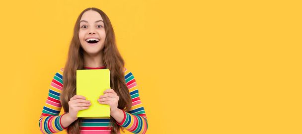 Ευτυχισμένο κορίτσι χαμόγελο κρατώντας το σχολικό βιβλίο κίτρινο φόντο, το σχολείο. Banner της μαθήτριας μαθήτριας. Μαθητικό πορτραίτο μαθητή με αντιγραφικό χώρο - Φωτογραφία, εικόνα