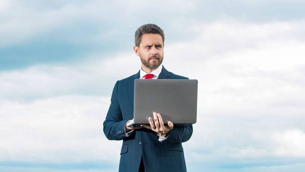 businessman in suit using computer on sky background. - Fotoğraf, Görsel