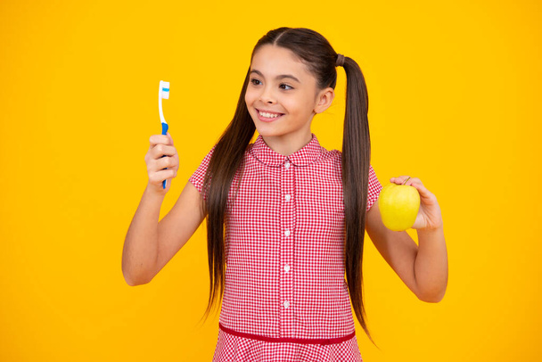 Girl cleaning teeth. Kid brushing teeth with brush. Dental hygiene, tooth care. Girl cares about health of his teeth. Happy teenager, positive and smiling emotions of teen girl - Foto, immagini