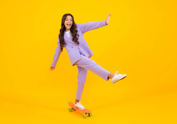 Amazed teen girl. Teenagers youth casual culture. Teen girl with skateboard over isolated studio background. Teenager in fashion stylish clothes. Excited expression, cheerful and glad - Fotografie, Obrázek