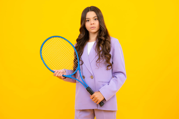 Teenage tenista dívka drží tenisovou raketu na izolovaném žlutém pozadí. Sport pro děti. Trénink pro malé dítě. Naučit se hrát tenis - Fotografie, Obrázek