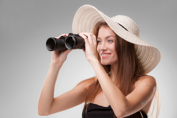 Young woman in hat with binoculars - Foto, afbeelding