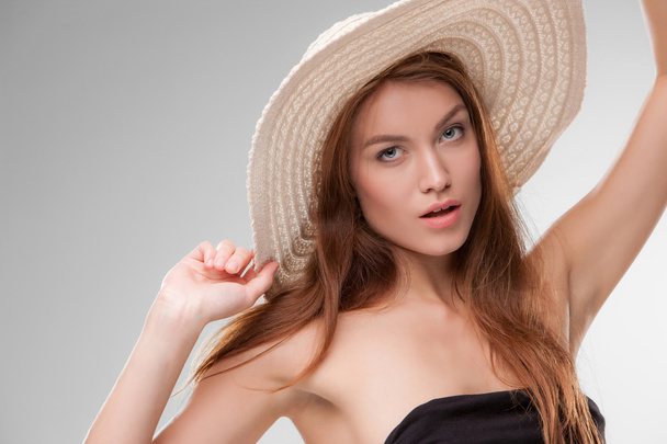 Beautiful girl with hat posing in studio - Фото, изображение