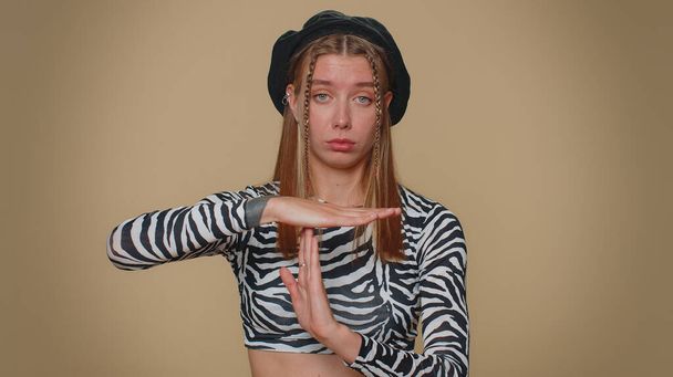 Time out, need a break. Tired serious upset pretty young woman in crop top showing pause relax gesture, limit or stop sign. Adult stylish female girl isolated alone on beige studio background indoors - Foto, Imagen