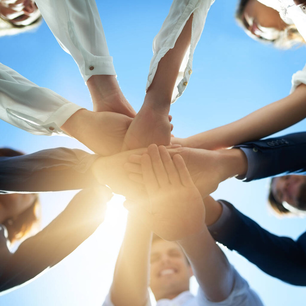 Theres nothing we cant do through teamwork. Low angle shot of a group of businesspeople joining their hands together in unity - Fotoğraf, Görsel