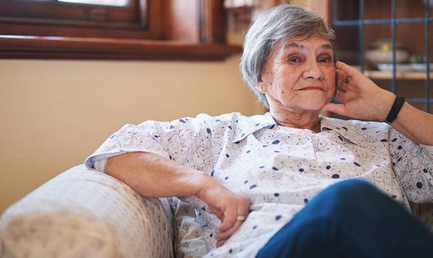 Portrait happy elderly woman smiling sitting on sofa at home enjoying retirement. - Foto, Bild