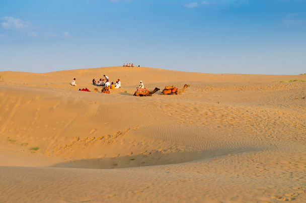 Tourists with camels, Camelus dromedarius, at sand dunes of Thar desert, Rajasthan, India. Camel riding is a favourite activity amongst all tourists visiting here. - 写真・画像