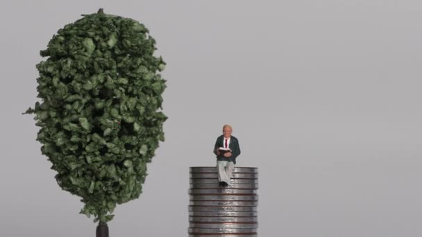 The concept of the gap between rich and poor. Business concept with piles of coins and miniature people. - Filmagem, Vídeo