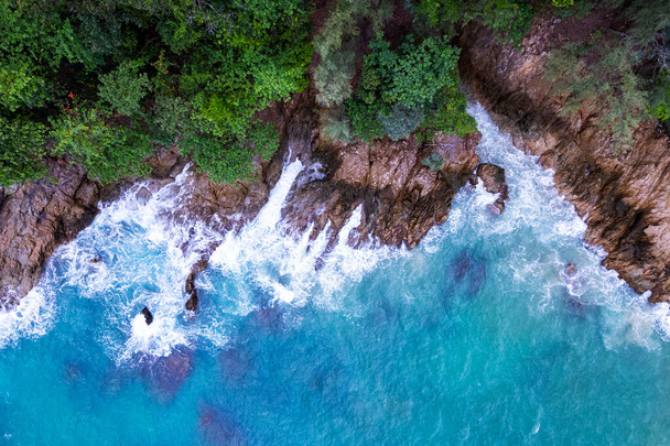 Aerial view Top down seashore big wave crashing on rock cliff Beautiful sea surface in sunny day summer background Amazing seascape top view seacoast at Phuket Thailand - Foto, afbeelding