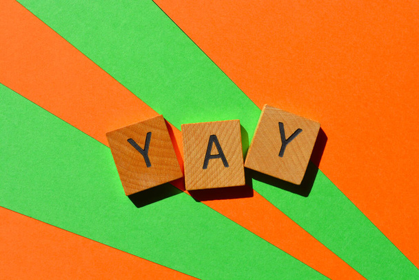 Yay, word in wooden alphabet letters isolated on bright and colourful background - Photo, Image
