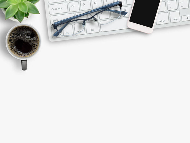 Клавиатура и кофе, смартфон, очки на белом фоне. Top view with copy space.Business office desk concept. - Фото, изображение