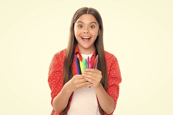 Portrait of excited teenager school girl with colorful pencils isolated on white background - Photo, image