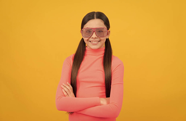 smiling kid in glamour party eyeglasses on yellow background, fancy look. - Photo, Image