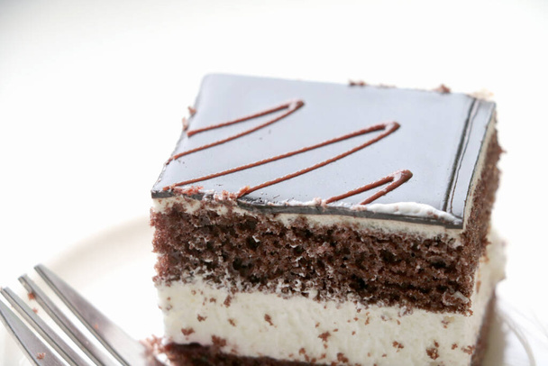 На белой тарелке вкусный торт с кофе или чаем - Фото, изображение