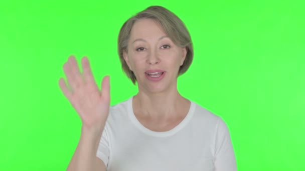 Senior Old Woman Waving Hand to Say Hello on Green Background  - Footage, Video