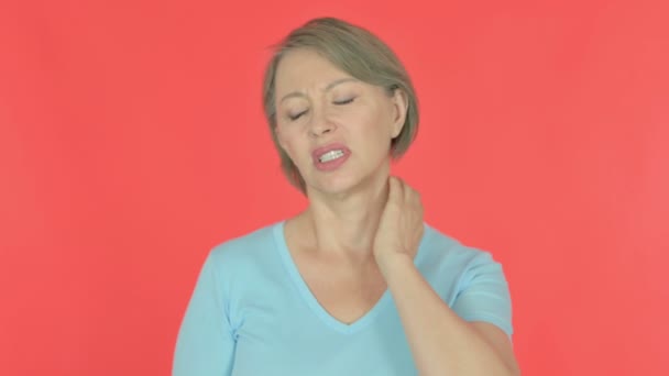 Ηλικιωμένη γυναίκα με πόνο στο λαιμό σε κόκκινο φόντο  - Πλάνα, βίντεο