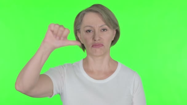 Thumbs Down by Senior Old Woman on Green Background  - Felvétel, videó