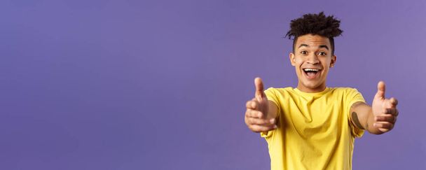 Close-up portrait of charismatic, happy friendly-looking hispanic man with dreads reaching hands forward to hold something, give hug or cuddle dearly, standing purple background. - Photo, Image