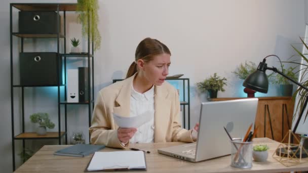 Stressed businesswoman in suit working looking at unpaid bank debt bills, doing paperwork, planning budget calculate finances mortgage payments at office. Displeased freelancer girl throws paper bills - Imágenes, Vídeo