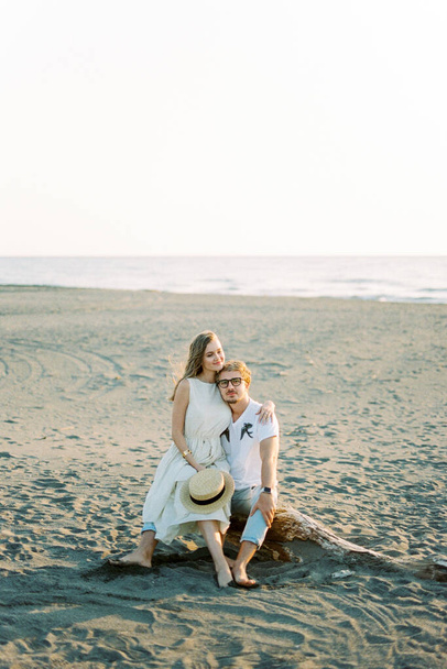 Young woman sitting on man lap on the beach. High quality photo - Photo, image