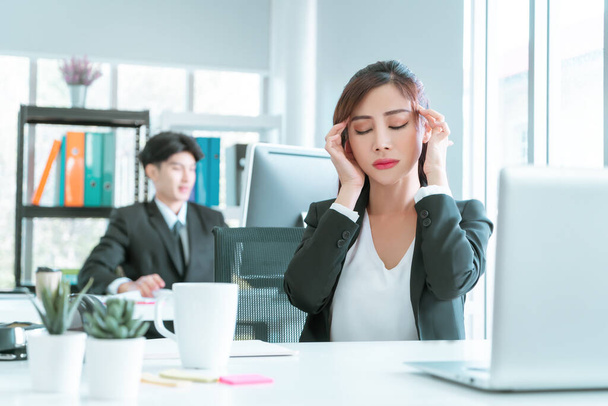 オフィスのパソコンの前で仕事をした後女性役員は片頭痛を持っていますオフィス症候群の概念. - 写真・画像