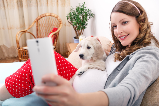 Femme enceinte avec son chien à la maison
 - Photo, image