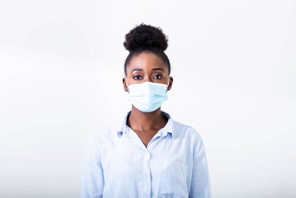 Naamioitunut nainen - suoja influenssavirusta vastaan. Afrikkalainen Amerikkalainen nainen yllään naamio suojelemiseksi. Naisella on suojaava kasvonaamio kotona. Pysäytä virus ja epidemiataudit. - Valokuva, kuva