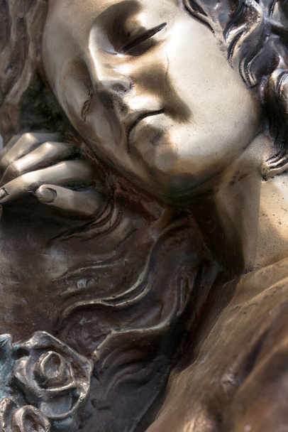 Παλιό γλυπτό μιας θλιμμένης γυναίκας που πενθεί. Χάλκινο άγαλμα της Παναγίας. Θρησκεία, πίστη, βάσανα, έννοια του θανάτου. - Φωτογραφία, εικόνα