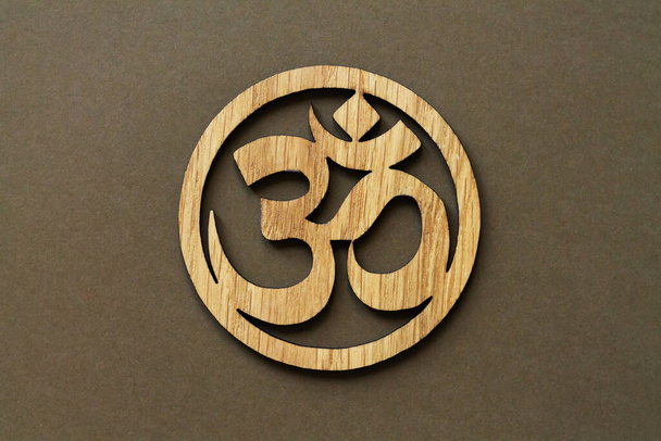 Wooden Om or Aum symbol of Hinduism and Buddhism on brown background - Zdjęcie, obraz