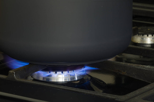 A black pan cooking on natural gas. Concept for gas crisis. - 写真・画像