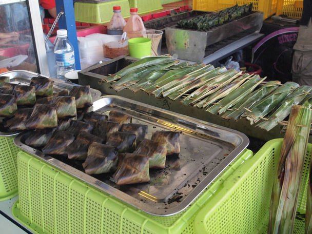 Satar is an exotic food very popular in peninsular Malaysia. It is made of raw fish and coconut, wrapped in fresh banana leaf. It has to be roasted before served. - Zdjęcie, obraz