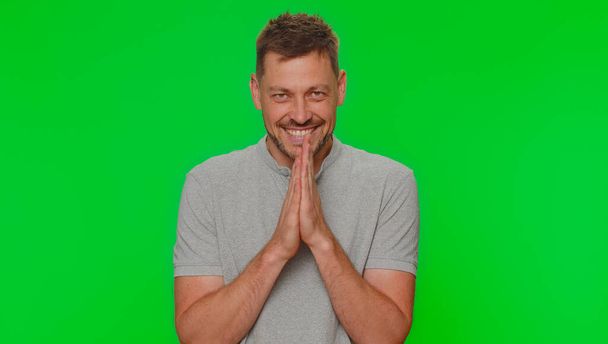 Sneaky cunning handsome man with tricky face gesticulating and scheming evil plan, thinking over devious villain idea, cunning cheats, jokes and pranks. Adult guy on green chroma key studio background - Foto, immagini