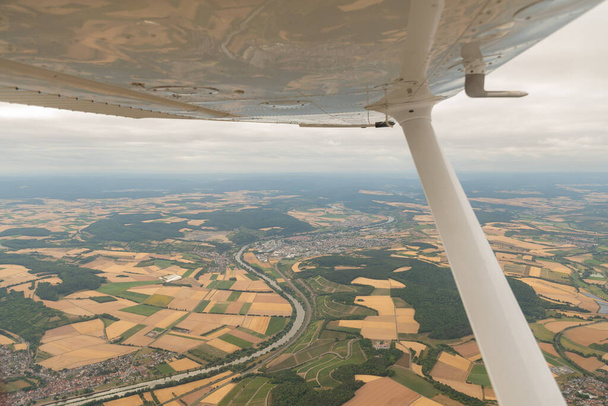 Karlstadt, Bavaria, Germany, July 10, 2022 Flight abeam the city in a small plane - Photo, image