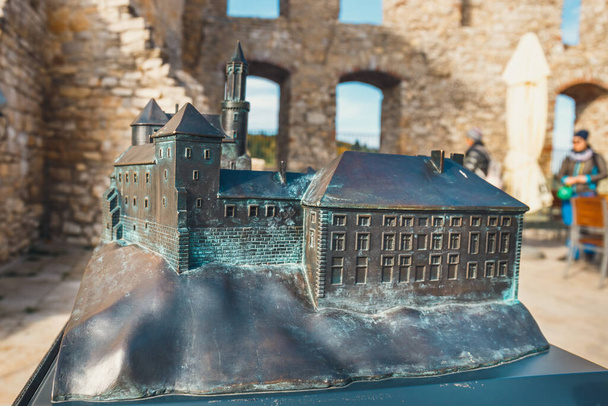 небольшая модель Рабштынского замка с реальным зданием на заднем плане, система Брайля - Фото, изображение