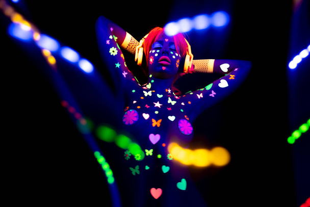 Havalı seksi dans eden kadın UV floresan giysiler ve makyaj giyiyor. - Fotoğraf, Görsel
