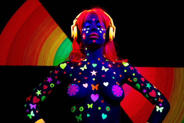 Una mujer sexy bailando con ropa fluorescente UV y maquillaje - Foto, imagen
