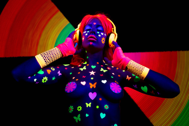 Крута сексуальна танцююча жінка в ультрафіолетовому флуоресцентному одязі та макіяжі
 - Фото, зображення
