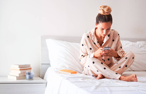 Mladá dívka pomocí smartphone v posteli - Teenager sledování videa on-line - Fotografie, Obrázek