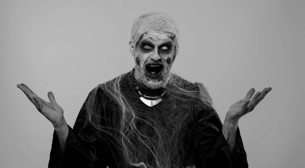 O mój Boże, Wow. Przerażający człowiek z zombie Halloween krwawy makijaż rannych podnoszących ręce w zaskoczeniu patrząc na aparat z dużymi oczami, zszokowany nagłym zwycięstwem. Podekscytowany złowieszczym nieumarłym facetem - Zdjęcie, obraz