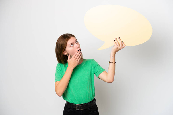 Young English woman isolated on white background holding an empty speech bubble with surprised expression - Fotó, kép