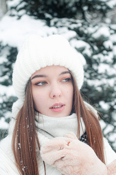 щаслива жінка в капелюсі і шарф на сніжному тлі в лісі зі сніжним пейзажем
. - Фото, зображення