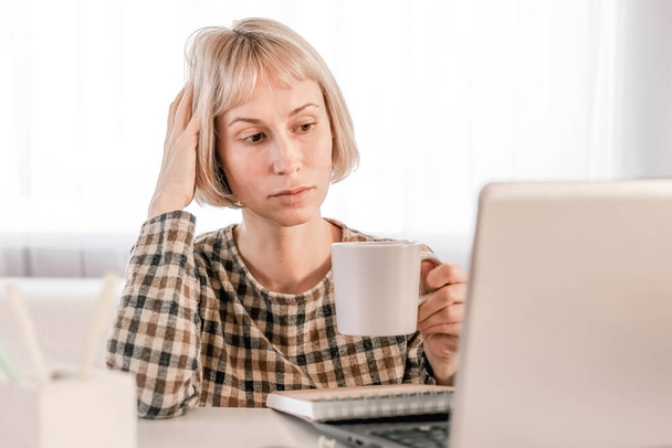 Ділова жінка слухає освітню лекцію на комп'ютері, дивиться вебінар, вивчає онлайн-курси, пише нотатки в паперовій копії, концепція електронного навчання
 - Фото, зображення