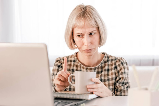 Бизнес-женщина слушает образовательную лекцию на компьютере, смотрит веб-бинар, учится на онлайн-курсах, пишет заметки в бумажной копировальной книге, концепция электронного обучения - Фото, изображение