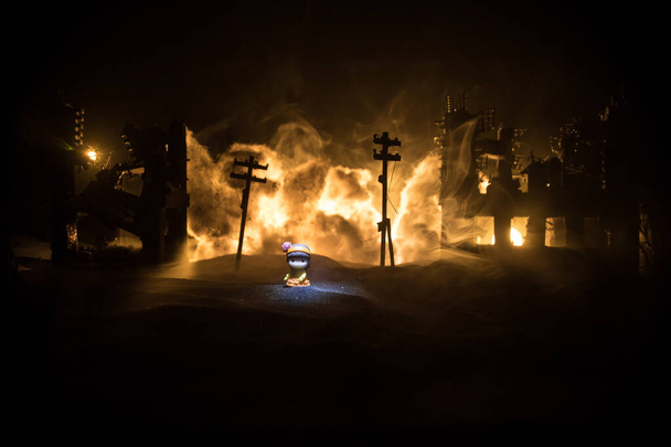 La muerte de los niños en la guerra. La guerra rusa en Ucrania concepto. Obra creativa de muñequita yace en el suelo en la ciudad quemada. Enfoque selectivo - Foto, Imagen